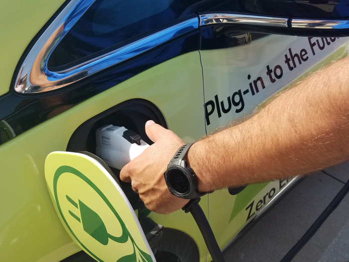 man charging electric vehicle