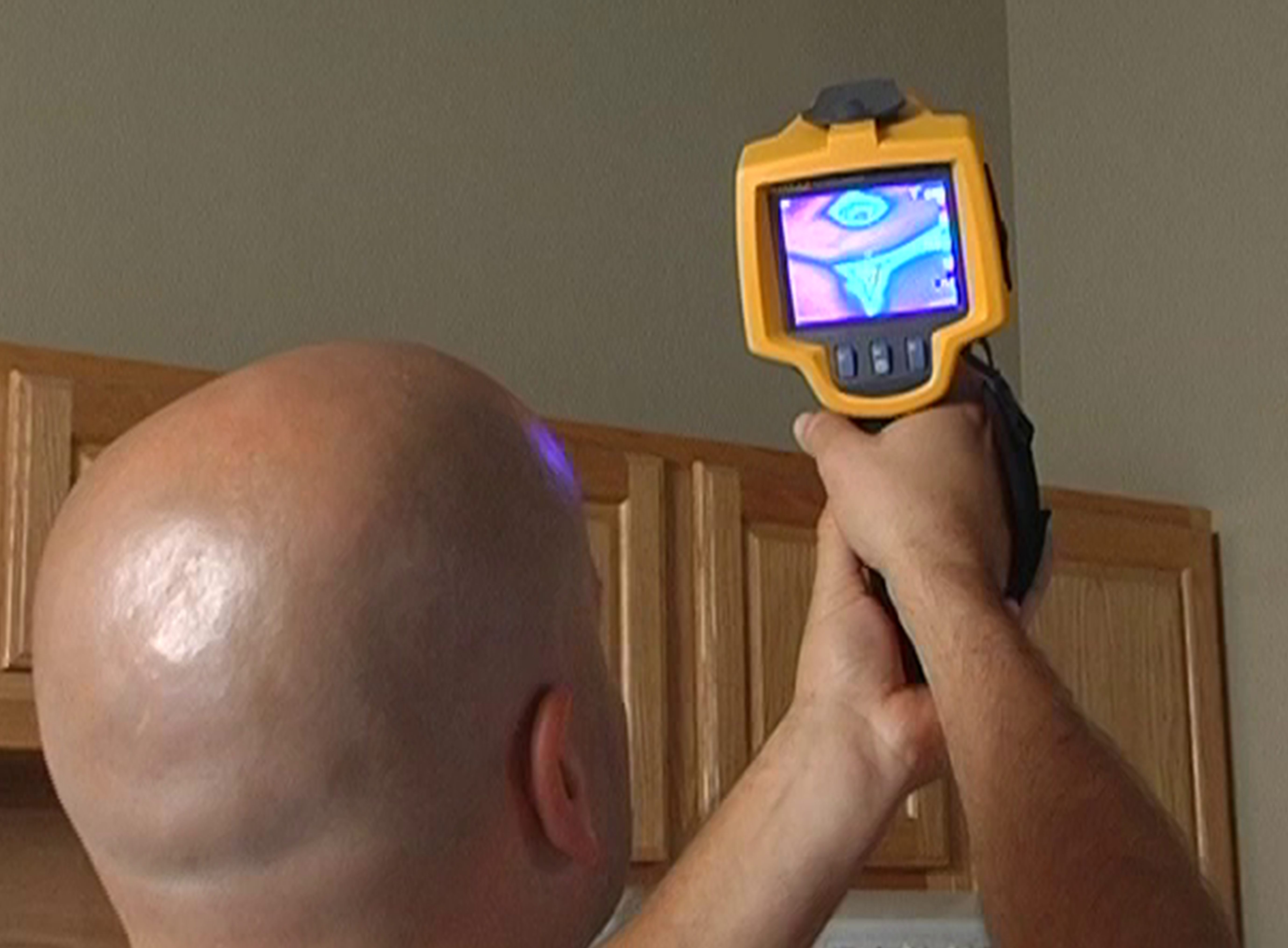 man using heat mapping device in home