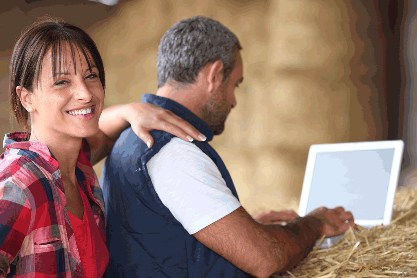 man and woman on computer surrounded by hay