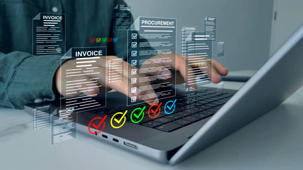 Image of a person using a laptop to create and process invoices for a work setting.