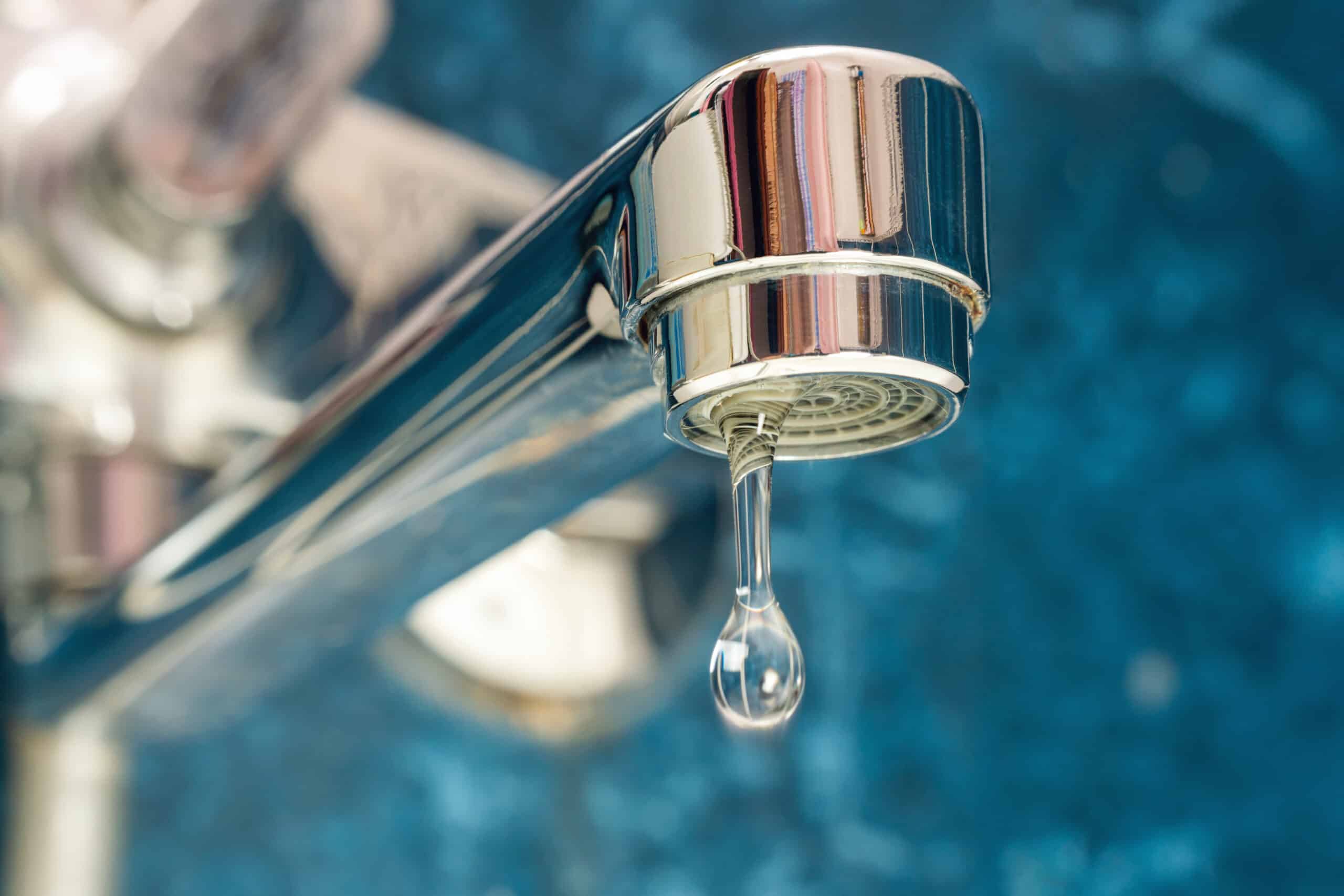 A drop of water drips from a leaky faucet
