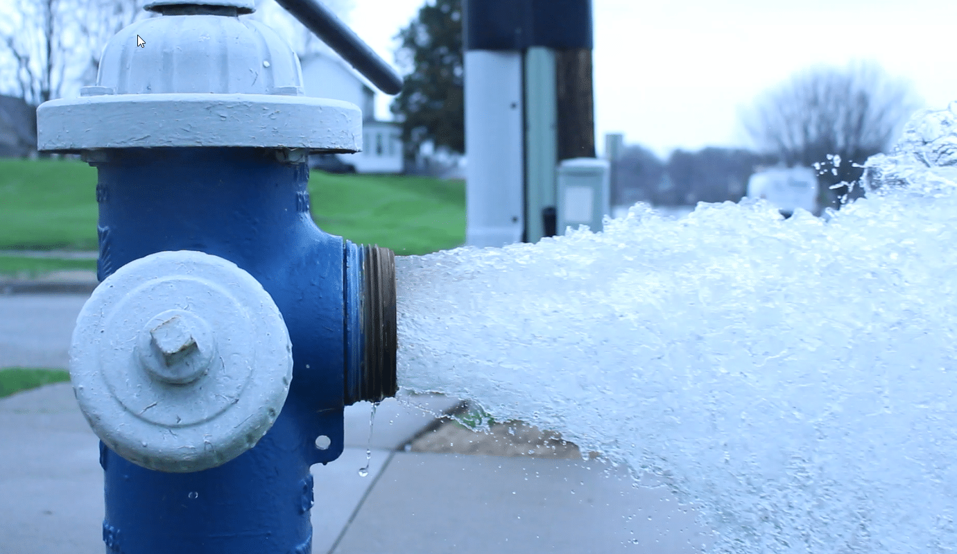 Picture of hydrant being flushed in Muscatine flowing water
