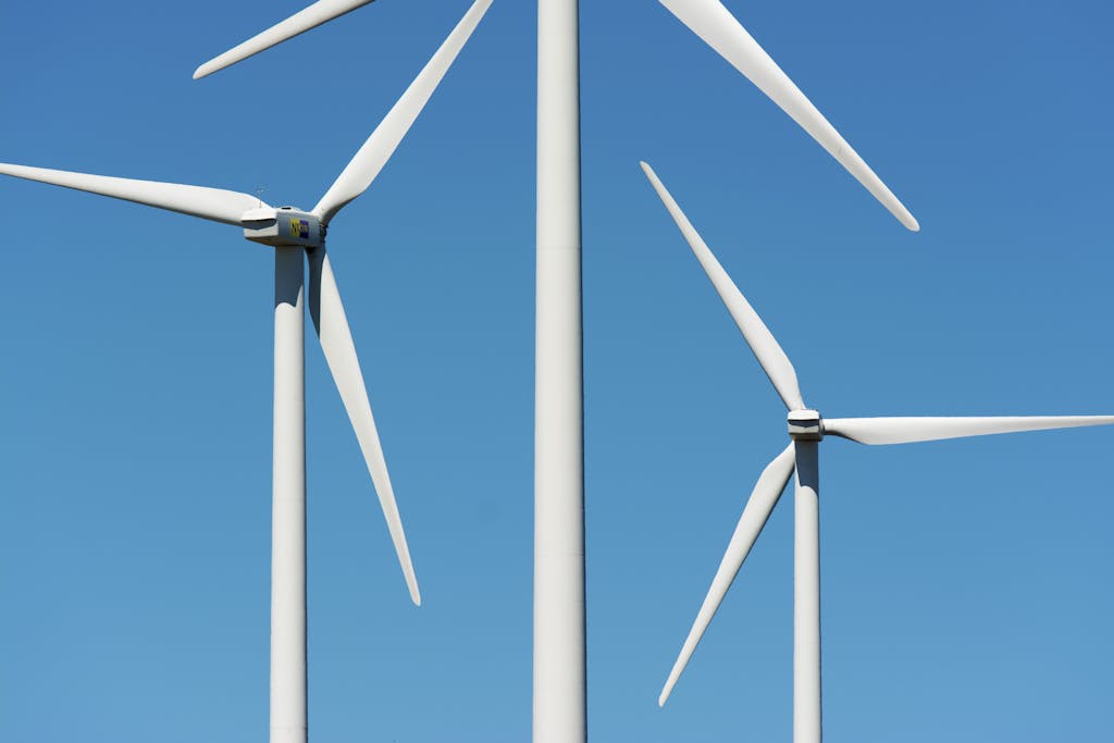 Close-up view of wind turbines generating clean energy against a clear blue sky.