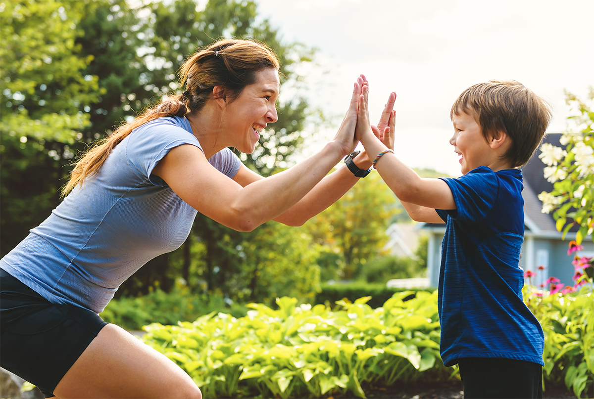 woman-and-child-high-fiving a woman and child high fiving in front of a garden and house